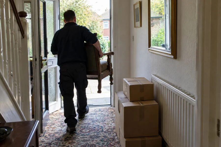 Furniture being carried out of a house during a clearance